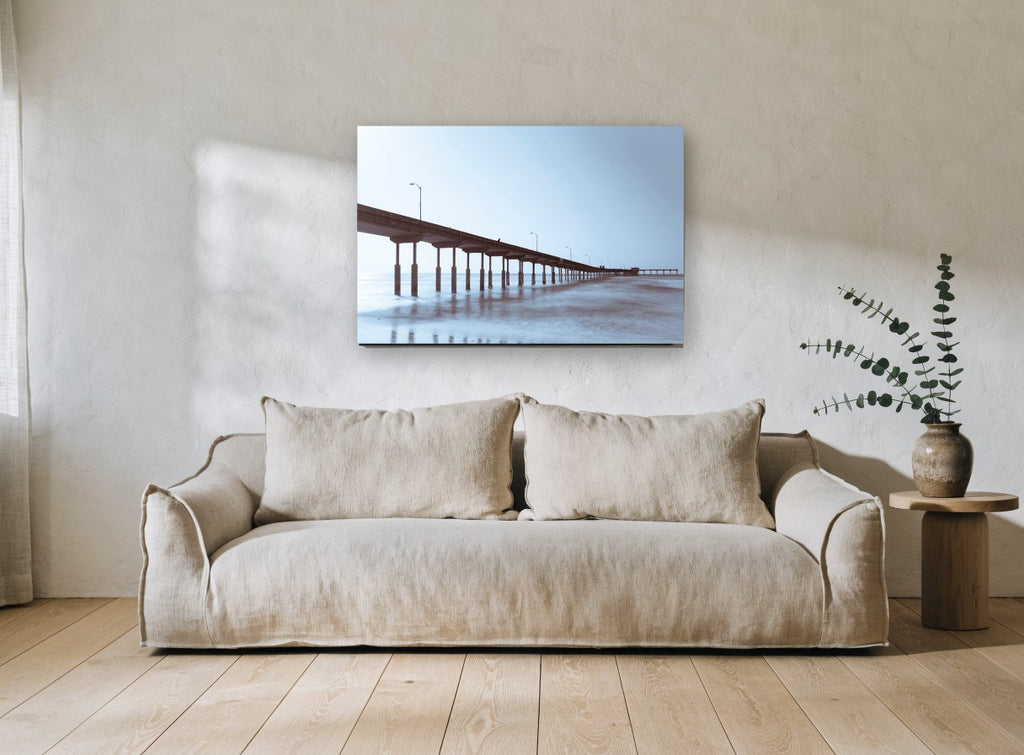 Pier in Blue Haze coastal canvas print on the wall of a living room