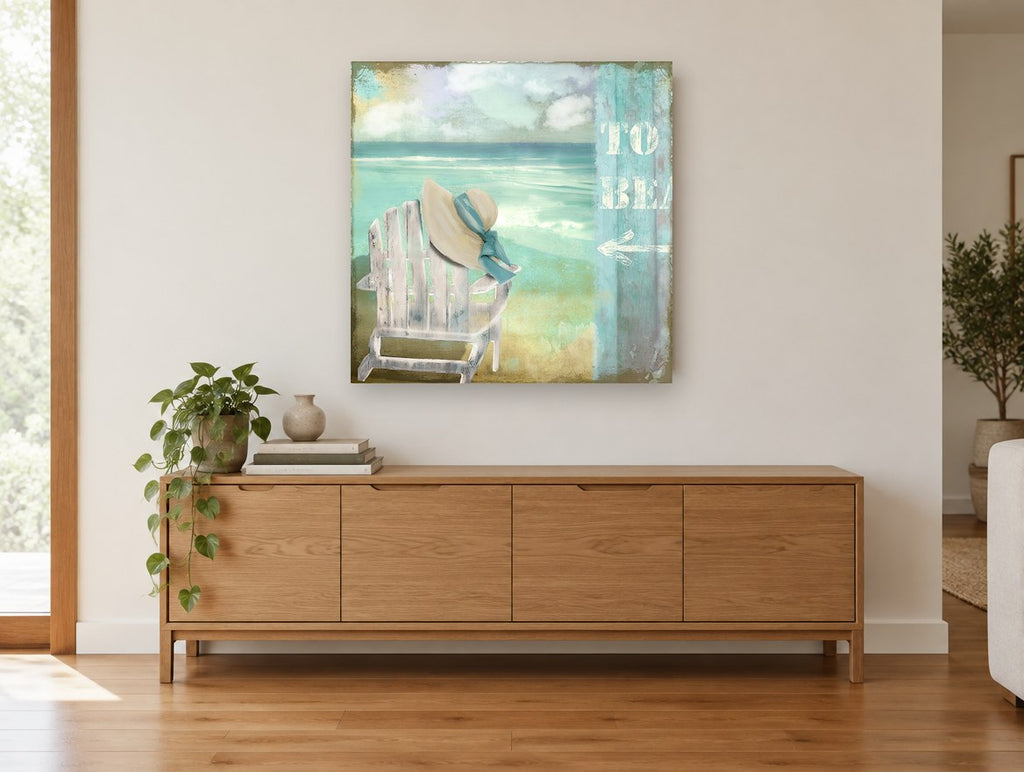 Hat on the Beach Chair coastal canvas print on the wall of a living room above a sideboard