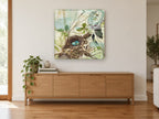 Robin's Nest Collage floral canvas print on the wall of a living room above a sideboard