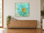 Aqua Peony Script floral canvas print on the wall of a living room above a sideboard