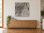 Zebra in the Reeds animal canvas print on the wall of a living room above a sideboard