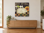 Bunny Hop Sunflower floral canvas print on the wall of a living room above a sideboard