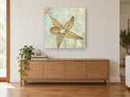 Starfish Shore Script coastal canvas print on the wall of a living room above a sideboard