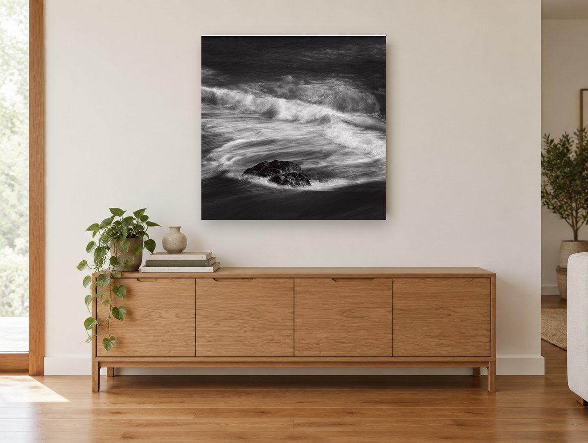 Rock in Swirling Surf coastal canvas print on the wall of a living room above a sideboard