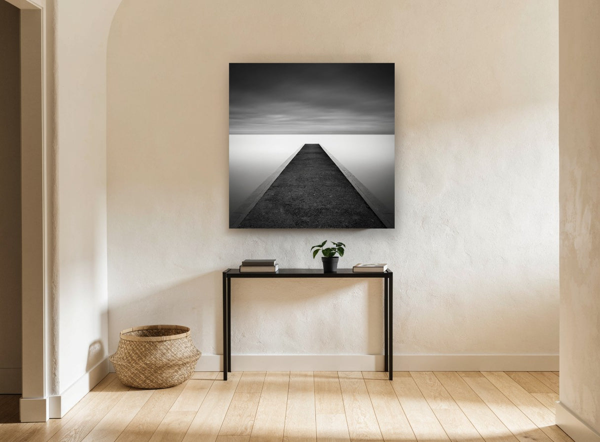 Concrete Jetty Stillness coastal canvas print on the wall of a hallway