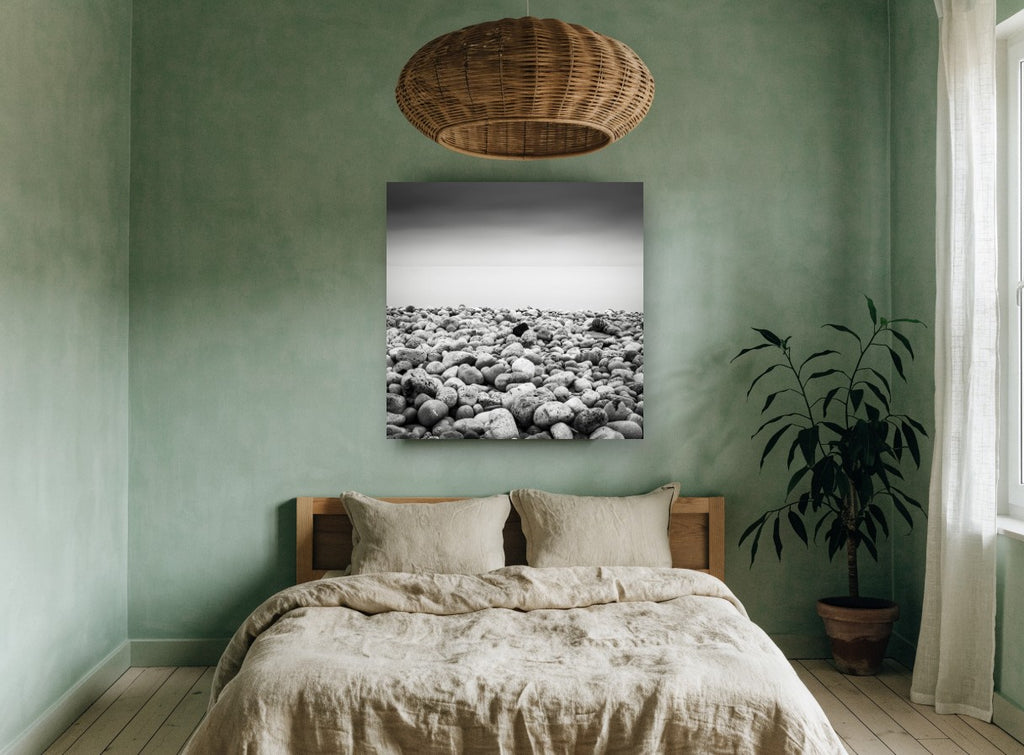Pebble Shore Stillness coastal canvas print on the wall of a bedroom