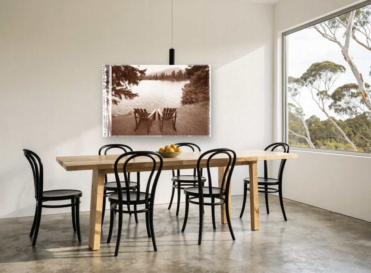 Two Chairs Lakeside landscape canvas print on the wall of a dining room