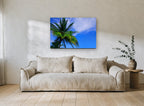 Palm Against Blue landscape canvas print on the wall of a living room