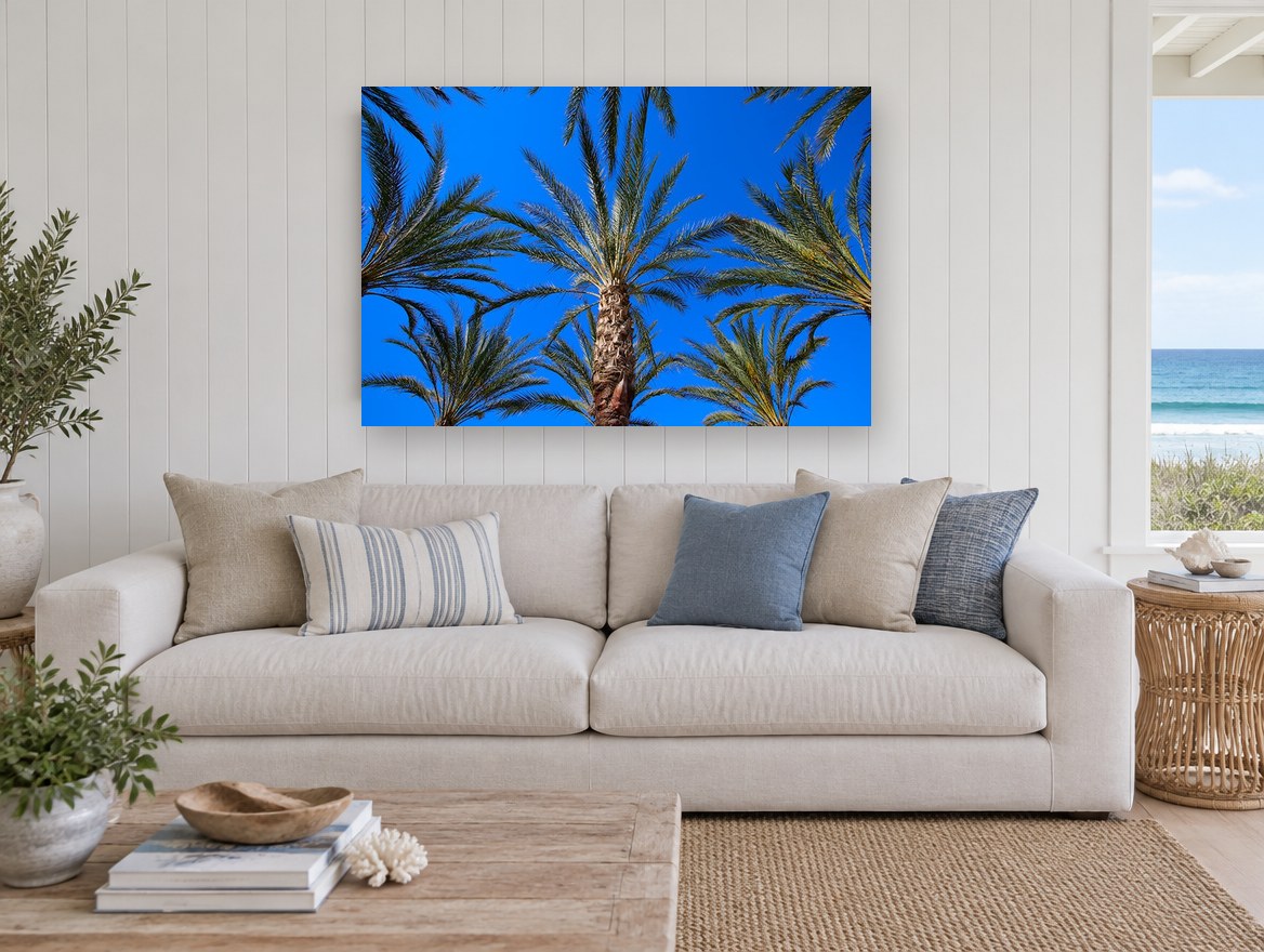 Palms Against Blue landscape canvas print on the wall of a beach house living room