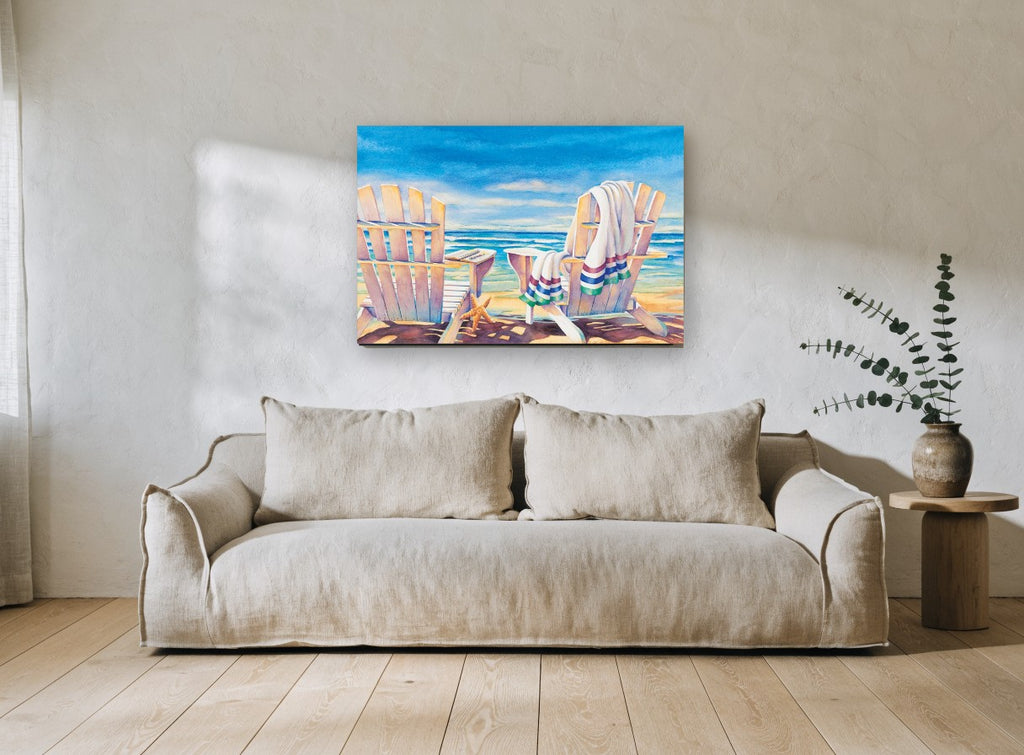 Two Chairs Seaside Rest coastal canvas print on the wall of a living room