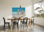Three Girls at Water's Edge coastal canvas print on the wall of a dining room