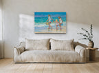 Three Girls at Water's Edge coastal canvas print on the wall of a living room