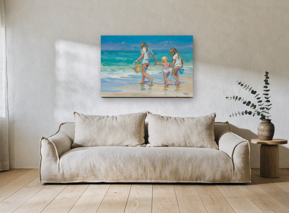 Three Girls at Water's Edge coastal canvas print on the wall of a living room