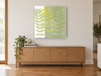 Layered Green Fronds floral canvas print on the wall of a living room above a sideboard