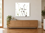 Two Birds Among Seedheads floral canvas print on the wall of a living room above a sideboard