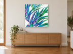 Jewel Palm Fronds floral canvas print on the wall of a living room above a sideboard