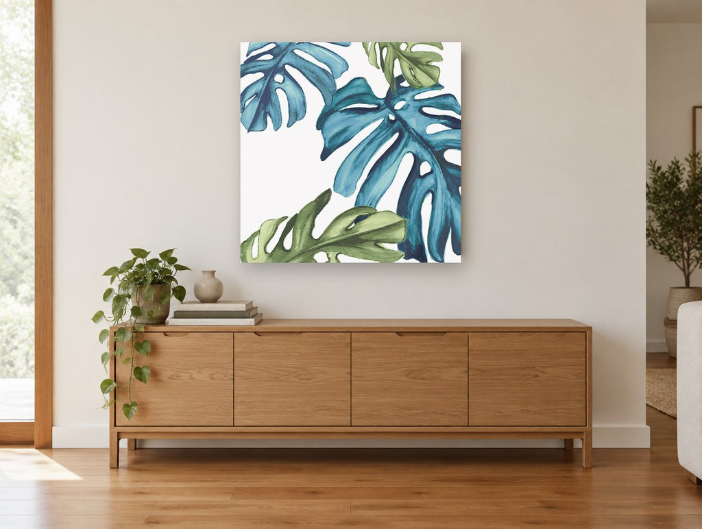 Teal Monstera Drift floral canvas print on the wall of a living room above a sideboard
