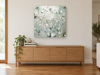 Misty Blossom Sprigs floral canvas print on the wall of a living room above a sideboard