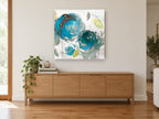 Teal Bloom Drift floral canvas print on the wall of a living room above a sideboard