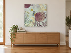 Rose and Butterfly Garden vintage canvas print on the wall of a living room above a sideboard