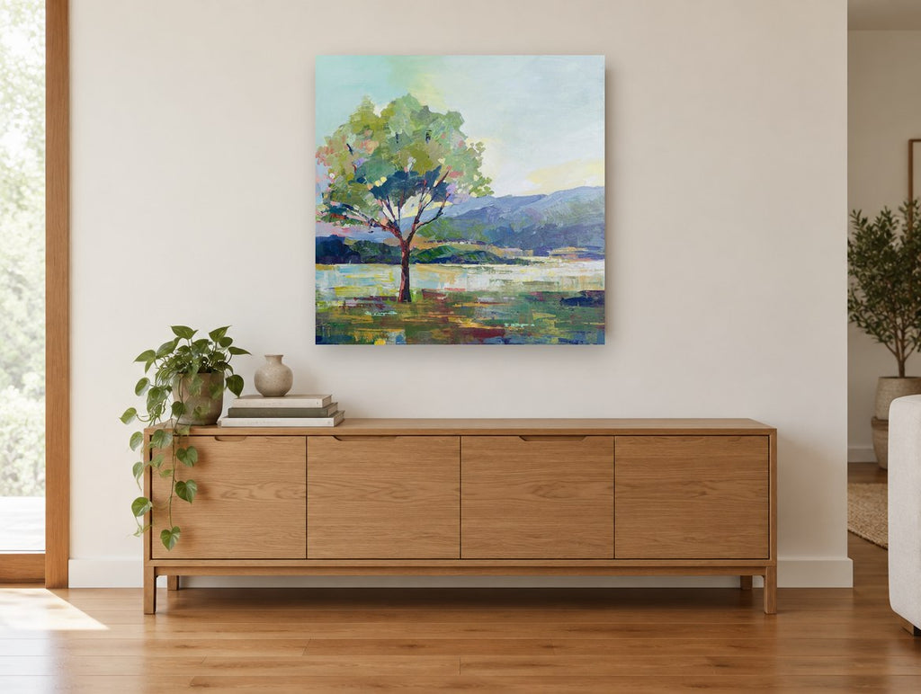 Lone Tree Lakeside landscape canvas print on the wall of a living room above a sideboard