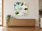 Translucent Teal Blossoms floral canvas print on the wall of a living room above a sideboard