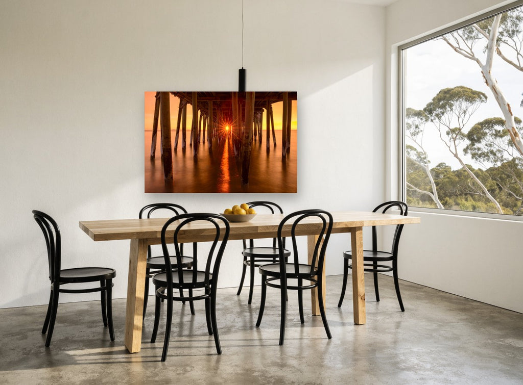 Sunburst Beneath the Pier coastal canvas print on the wall of a dining room