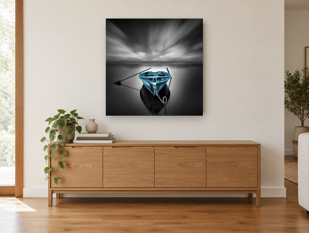 Blue Boat Still Water coastal canvas print on the wall of a living room above a sideboard