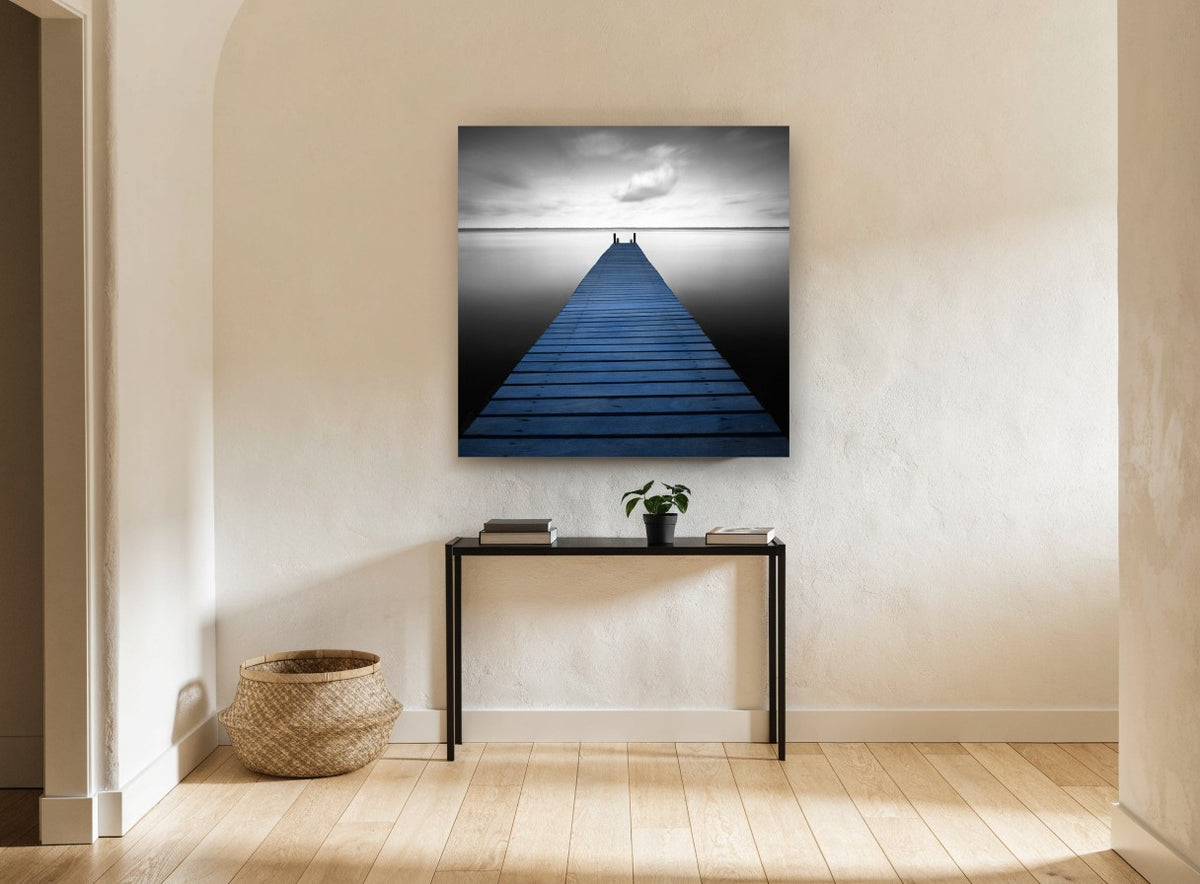 Blue Jetty Stillness coastal canvas print on the wall of a hallway