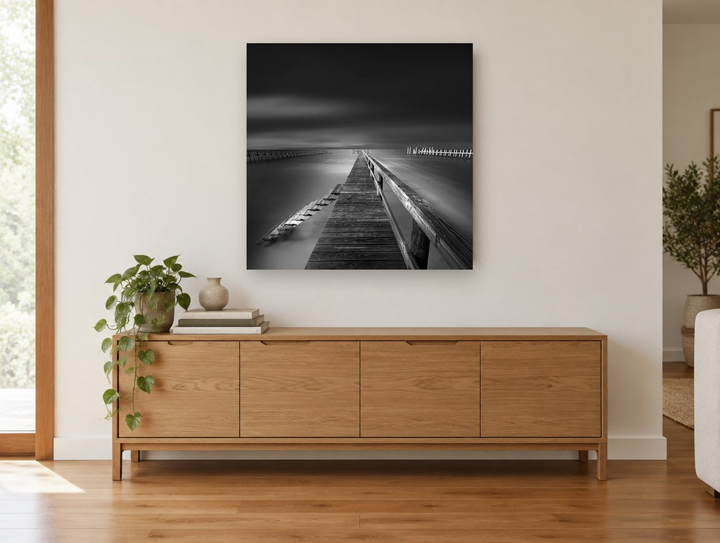 Silent Jetty Noir coastal canvas print on the wall of a living room above a sideboard