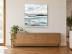 Pale Tide Layers coastal canvas print on the wall of a living room above a sideboard
