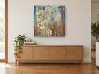 Cream Blooms in Rust Rain floral canvas print on the wall of a living room above a sideboard