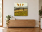 Three Amber Trees floral canvas print on the wall of a living room above a sideboard