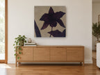 Aubergine Orchid Silhouette floral canvas print on the wall of a living room above a sideboard