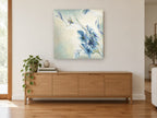 Windswept Blue Blooms floral canvas print on the wall of a living room above a sideboard