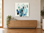 Drifting Teal Leaves floral canvas print on the wall of a living room above a sideboard