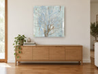 Silver Branch Haze floral canvas print on the wall of a living room above a sideboard