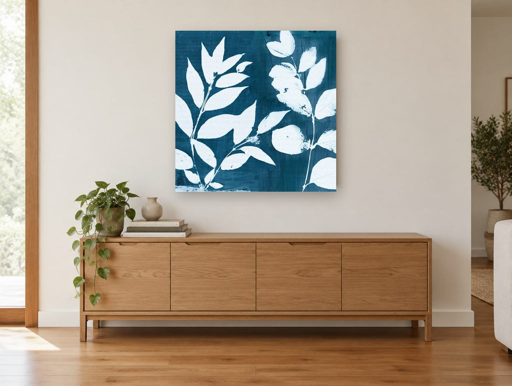 Indigo Leaf Silhouettes floral canvas print on the wall of a living room above a sideboard