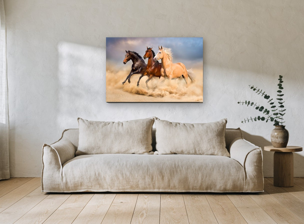 Three Horses Galloping landscape canvas print on the wall of a living room