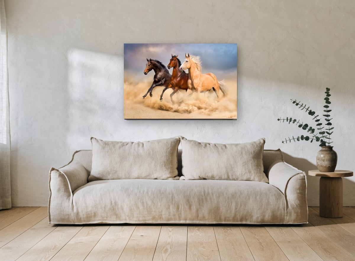 Three Horses Galloping landscape canvas print on the wall of a living room