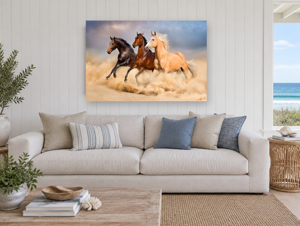 Three Horses Galloping landscape canvas print on the wall of a beach house living room