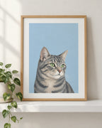 Personalised cat portrait print of a tabby cat on a sky blue background in an oak frame