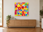 Rainbow Gerbera Bloom floral canvas print on the wall of a living room above a sideboard