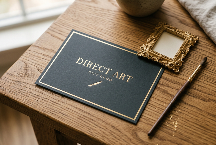 Direct Art Australia gift card with gold foil lettering beside an ornate gold frame