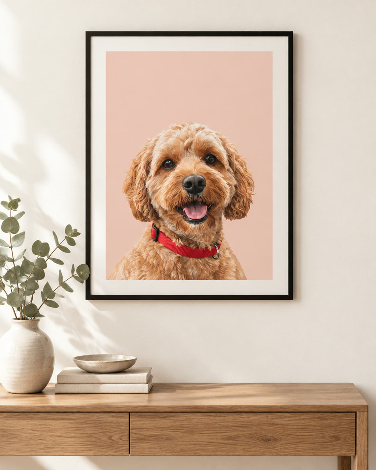 Personalised dog portrait print on a blush pink background in a black frame above a console